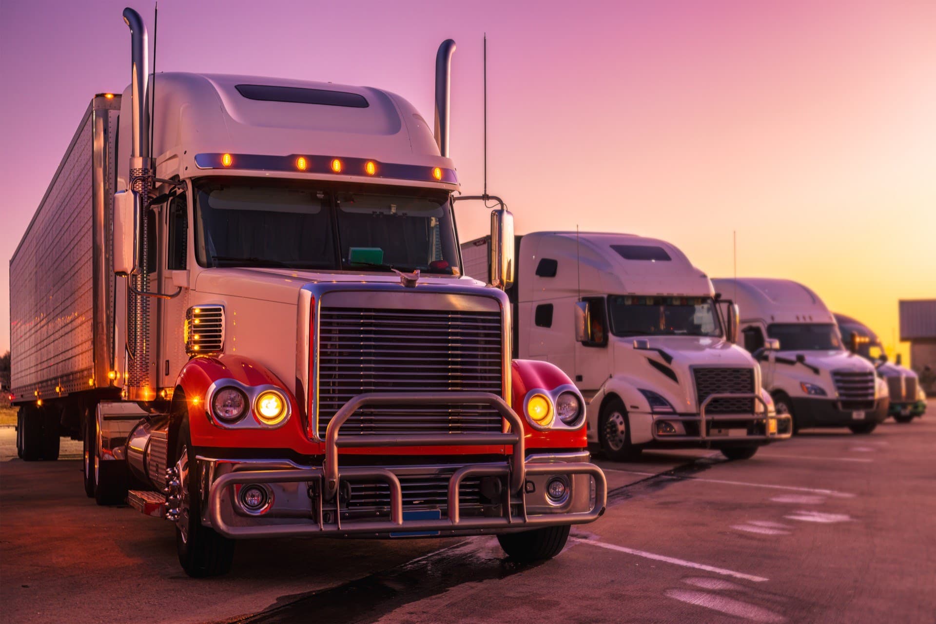 Row of commercial freight trucks at a Jacksonville, FL truck stop at sunset