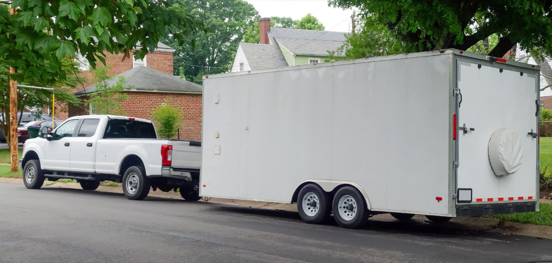 Pickup truck towing an enclosed cargo trailer serviced by Florida Truck Body in Jacksonville, FL